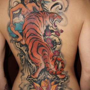 Ars Amandi, tatuaggio giapponese a colori su schiena con geisha e tigre.